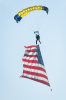 U.S. Army Parachute Team Golden Knight with large American flag falling from the sky